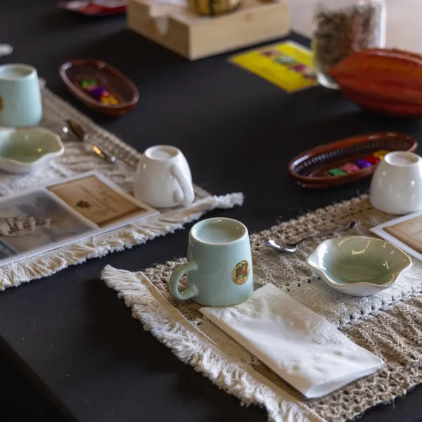 Table set with placemats, cups, saucers, and booklets for a chocolate tasting.