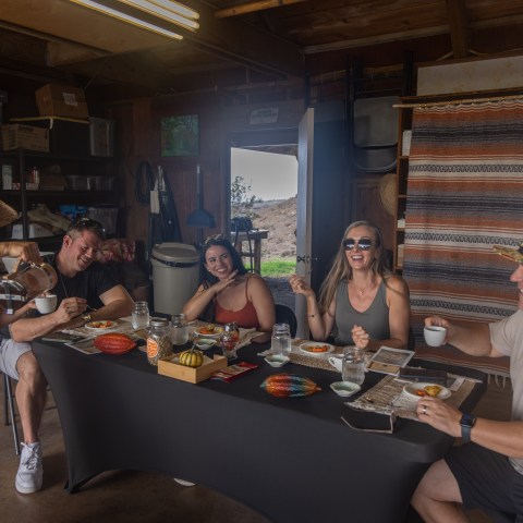 People enjoying coffee and snacks at a table in a rustic setting.